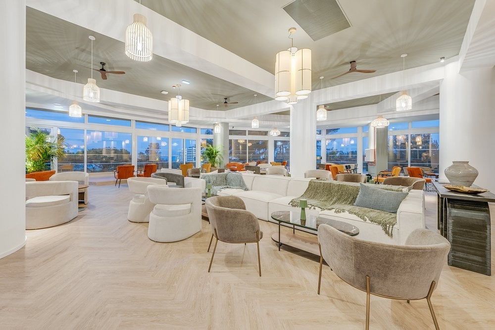 Modern luxury high-rise lounge with floor-to-ceiling windows, contemporary furniture, and city skyline views